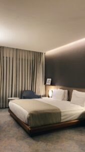 A person resting peacefully in a dark, cozy bedroom with soft lighting and a comfortable bed.