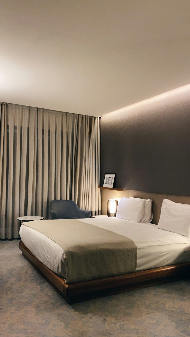 A person resting peacefully in a dark, cozy bedroom with soft lighting and a comfortable bed.