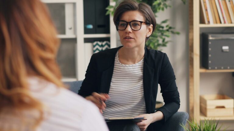 Person reviewing therapist notes during a quiet counseling consultation in a comfortable office.